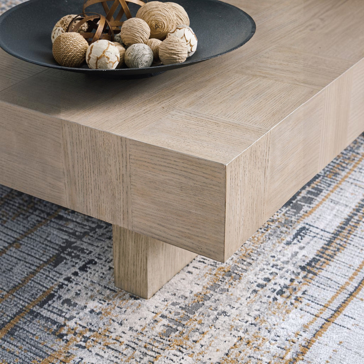 Sunset Sectionals Jorlaina rectangular cocktail table in light gray wire-brushed oak veneer with a plinth base.