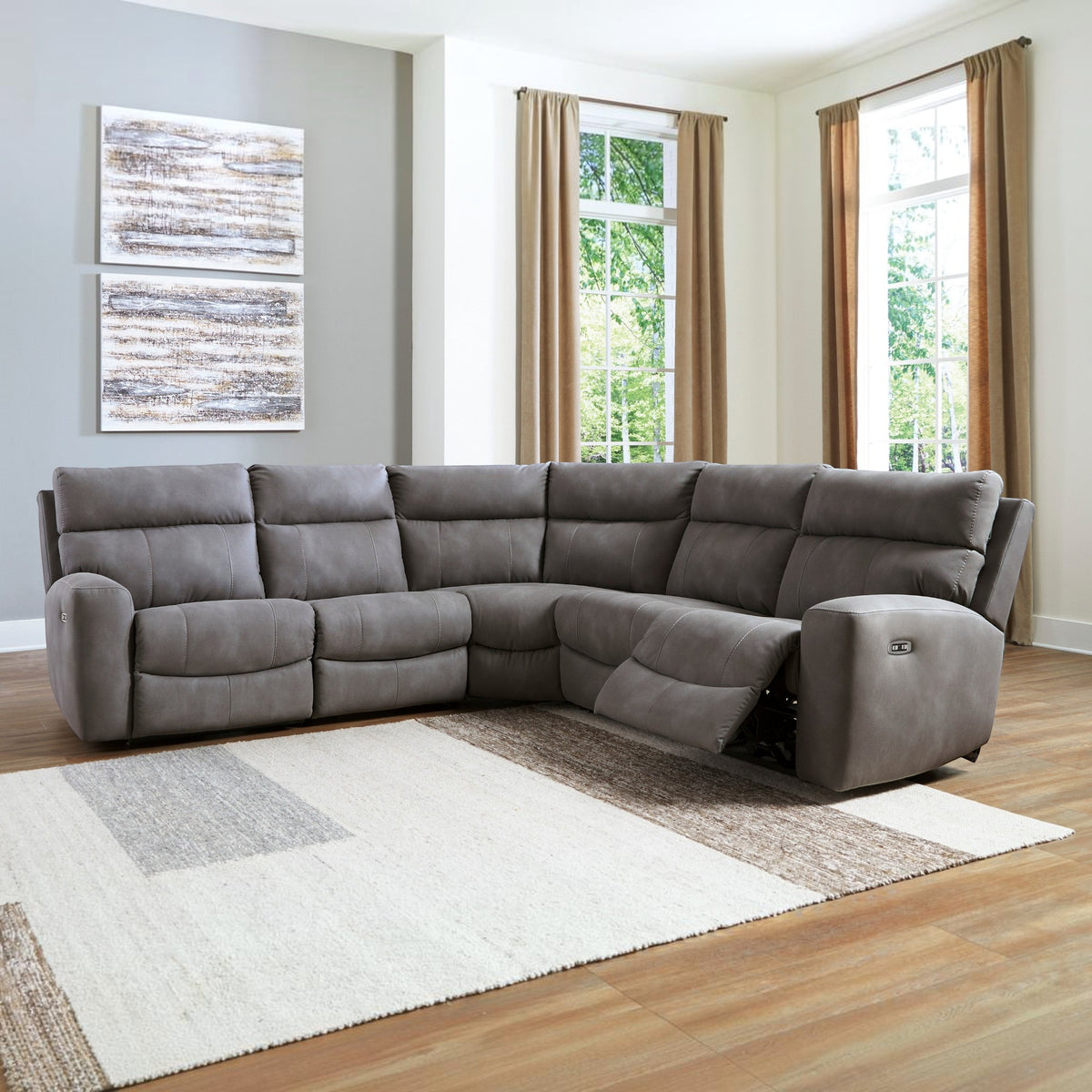 Sunset Sectionals sand-colored 5-piece modular power reclining sectional with adjustable headrests in a living room.