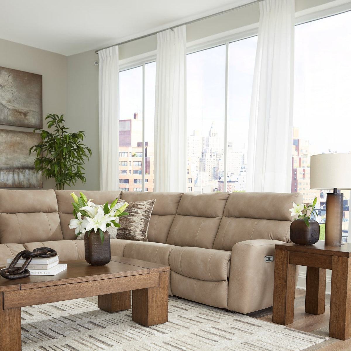 Sunset Sectionals sand-colored 5-piece power reclining sectional in a bright living room with wooden coffee table.
